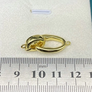 Macro shot of gold S925 sterling silver jewelry clasp measuring 28mm with a metal ruler