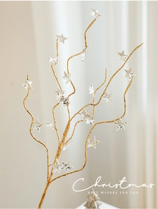 Macro view of golden decorative branches with transparent star pendants and glitter