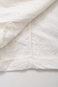 Detail of white blazer with intricate broderie anglaise embroidery and eyelet texture