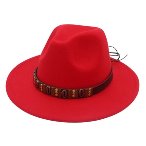 Detail of red fedora hat with ethnic style belt featuring metallic beads and shells