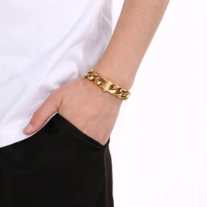 Detail of 13mm gold titanium steel Cuban chain bracelet worn on a male wrist