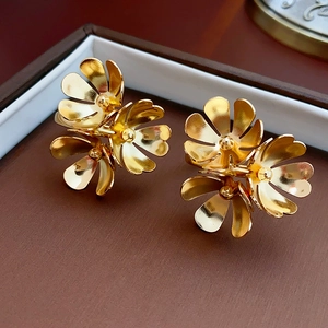 Macro shot of gold metallic triple flower cluster earrings placed in a jewelry box