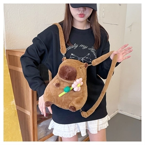 Cute brown plush capybara crossbody bag with pink flower detail worn by a model