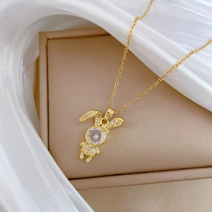 Detail of gold rabbit pendant necklace with sparkling cubic zirconia on white tulle