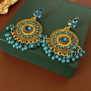 Detail of vintage gold-tone earrings with blue crystal flower and beaded fringe tassels