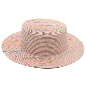Close-up of wide brim straw hat with artistic colorful spray paint and graffiti details