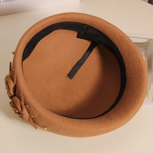 Detail of brown wool beret interior with adjustable ribbon, flower and pearl trim