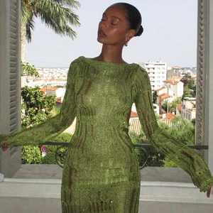 Detail showing the green crochet open-knit texture and sheer long sleeves on the dress