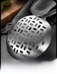 Macro shot of a stainless steel slotted spoon showing uniform holes and brushed metal texture