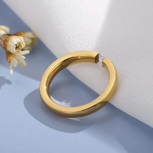 Polished gold stainless steel ring featuring a micro-set zircon in a minimalist design
