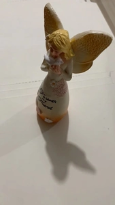 Detail of angel figurine with wings holding a dove and Forever my friend text