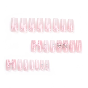 Pink gradient press-on nails with silver bows, rhinestones and glitter finish