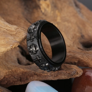 Detailed relief of skulls and crosses on a black matte titanium steel spinner ring