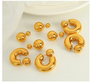Polished gold titanium steel ball studs and C-shaped earrings on minimalist background