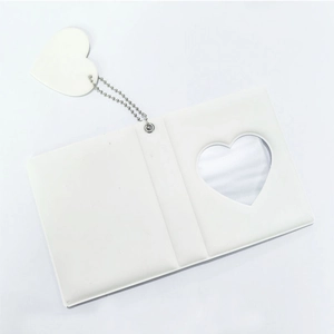 Detail of white photo album with heart cutout, silver reflective liner and ball chain charm
