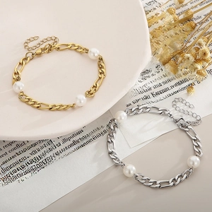 Detail of gold and silver Figaro chain bracelets with white pearls and adjustable clasp