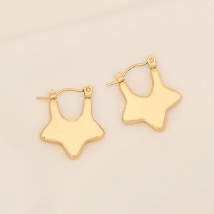 Macro view of geometric gold star earrings with shiny metallic finish on textured fabric