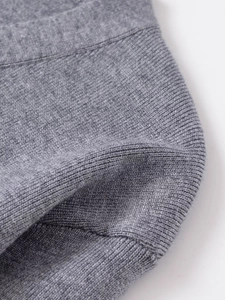 Macro texture of soft heather grey knit fabric showing premium stitching and material detail