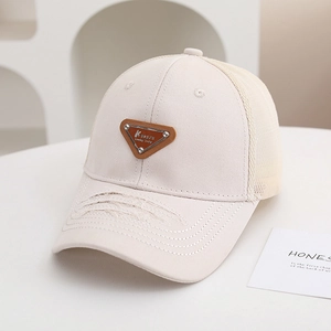 Dettaglio di un cappellino da baseball in rete per bambini color crema con visiera