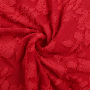 Macro del tessuto rosso con ricami floreali in pizzo 3D per vestito a spalle scoperte