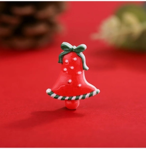 Macro view of Christmas bell resin DIY charm with red polka dots and green bow detail