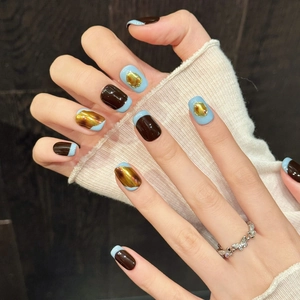 Kurze künstliche Nägel in Bernstein-Kaffee und Blau mit metallischen 3D-Goldakzenten und Design