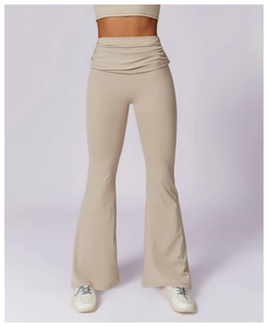 Detail of high-waist flared yoga pants with pleated waistband and light khaki finish