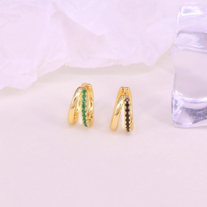 Detail of gold double-layer hoop earrings featuring green and black zircon gemstones