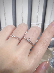 Dettaglio degli anelli in argento 925 con design intrecciato e piccoli cristalli lucidi