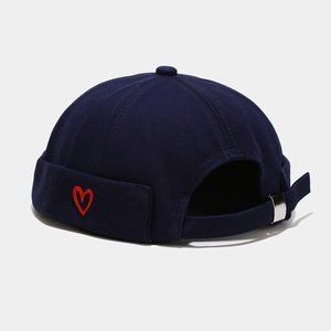 Detailed view of navy blue miki hat with red heart embroidery and metal buckle