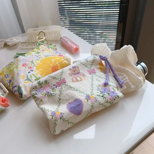 Detailed view of floral cotton mini pouches with zipper closure and woven labels