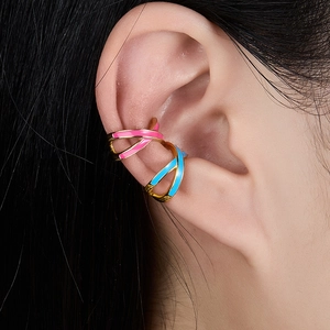 Close-up of pink and blue enamel double-layer crisscross ear cuffs on a model