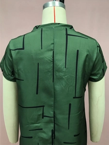Detail view of the green satin dress back with black geometric lines on the fabric