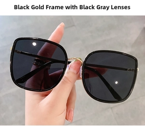 Close-up of oversized square sunglasses with black frame and gold metal bridge detail