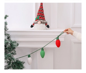 Close-up of knit Christmas light ornaments and plush gnome on a white mantelpiece