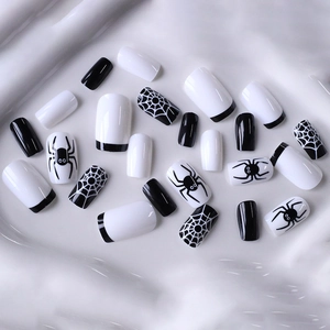 Halloween press-on nails featuring black spider web patterns and French square design