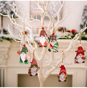 Close-up of wooden Christmas gnome ornaments hanging on white branches with festive decor