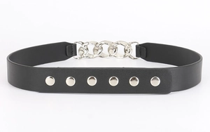 Detail of black leather corset belt featuring thick silver chains and round metallic studs