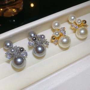 Vue détaillée de boucles d'oreilles dorées 14 carats avec perles grises et blanches et zircons