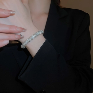 Close-up of sparkling silver rhinestone bracelet on wrist with elegant black background