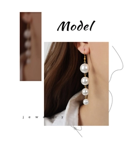 Detail showing elegant gradient faux pearl drop earrings with minimalist gold hooks