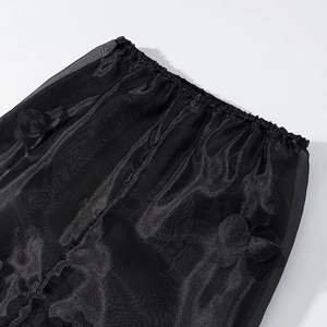 Détail de jupe en tulle noir avec broderies florales 3D et taille élastique souple