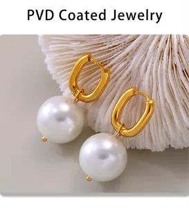 Macro detail of U-shaped gold earrings with white pearls and PVD plating finish