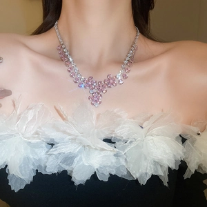 Dettaglio di una collana floreale con cristalli di zircone rosa sulla clavicola