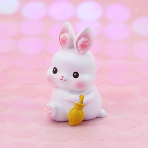Close-up of a cute white resin rabbit ornament holding a small yellow broom