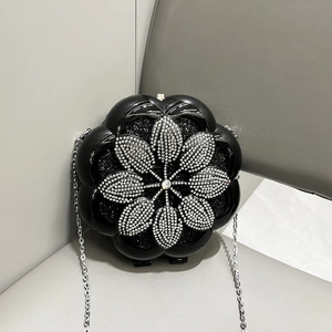 Close-up of black flower evening bag with silver rhinestones and metal chain strap