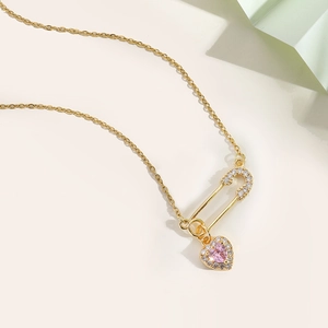 Detailed macro view of pink heart zircon pendant with pin safety clasp in 18K gold