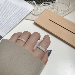 Detail view of shimmering frosted S925 sterling silver rings on a female model finger