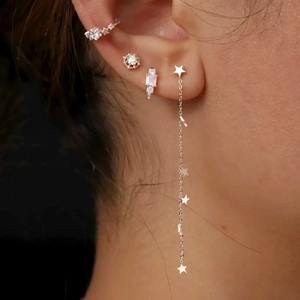Close-up of S925 silver star earrings set with tassel chain and opal stones on model