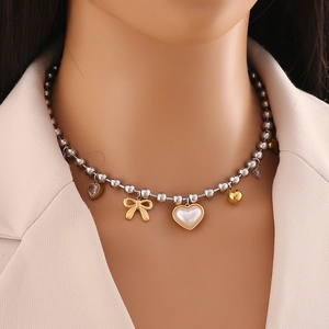 Two-tone necklace with pearl heart and golden bow charms on beaded stainless steel chain
